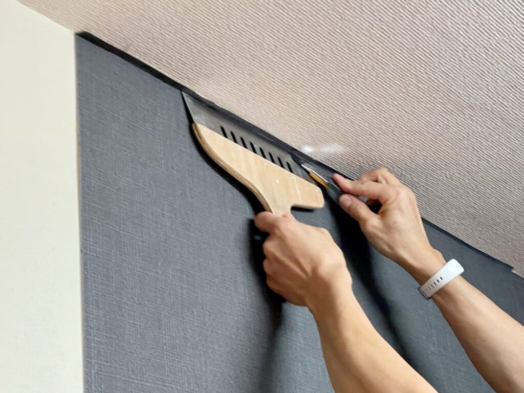 壁紙の貼り付け作業を行う職人の施工風景
