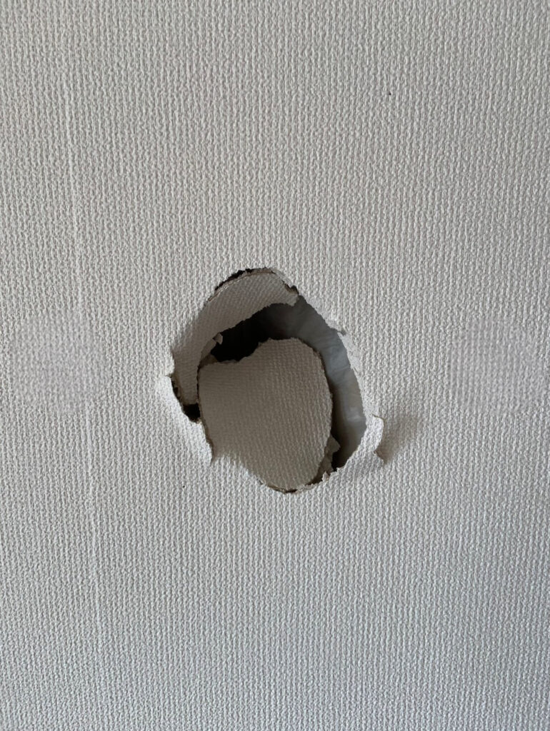 室内の壁に空いた円状の大きな穴を、部分リペアでどこかわからない仕上がりに